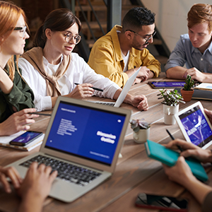 people gather on a table holding electronic devices