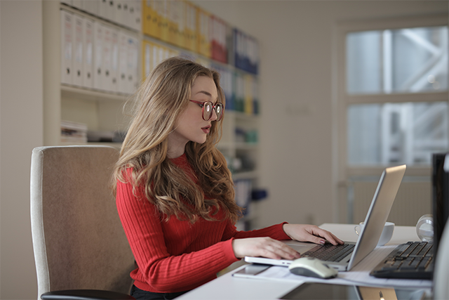 A girl working on laptop wearing glasses