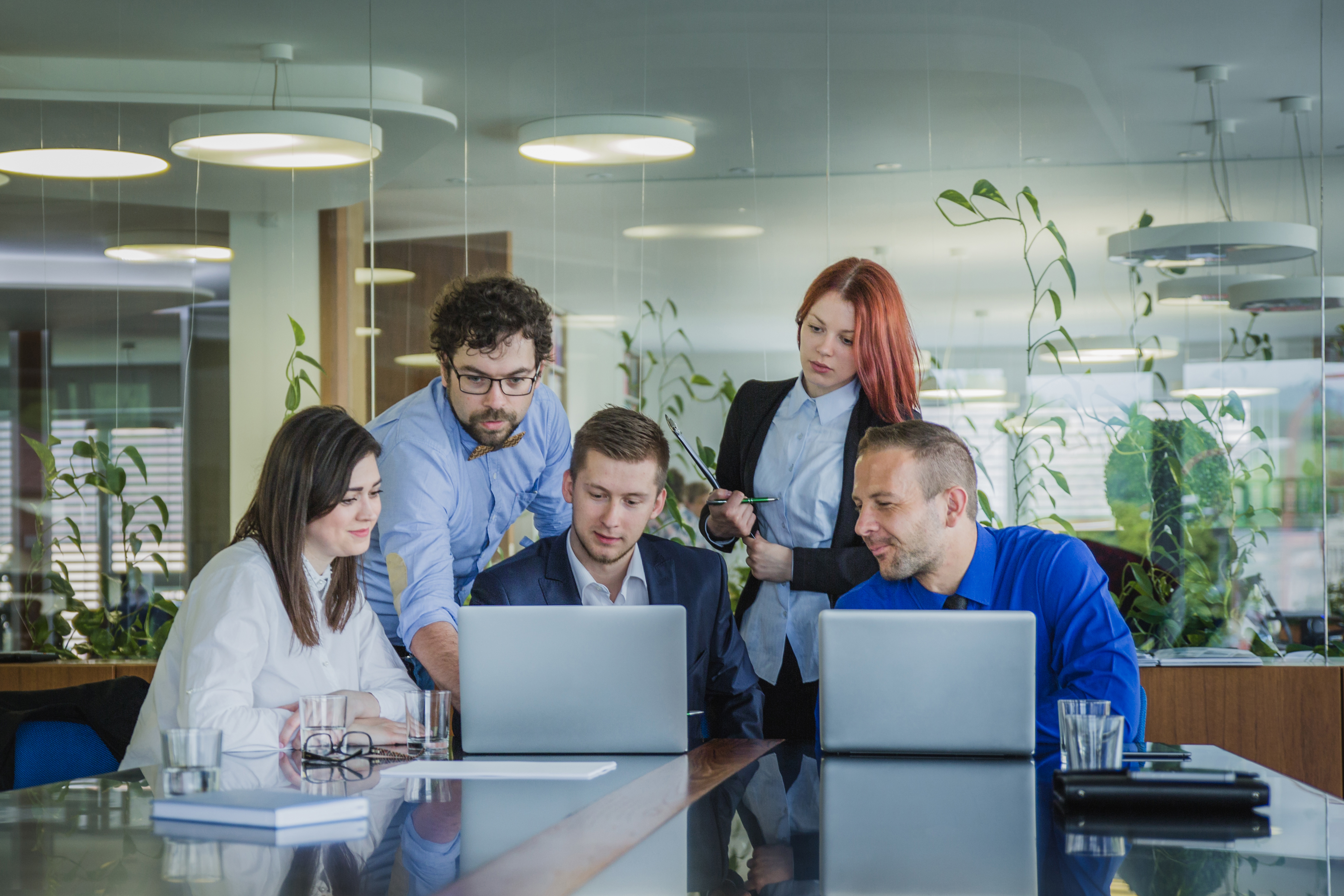 A-group-of-professionals-discussing-business-solutions-on-laptops-using-Microsoft-Power-Platform-Power-BI-and-Power-Apps-in-an-office-setting